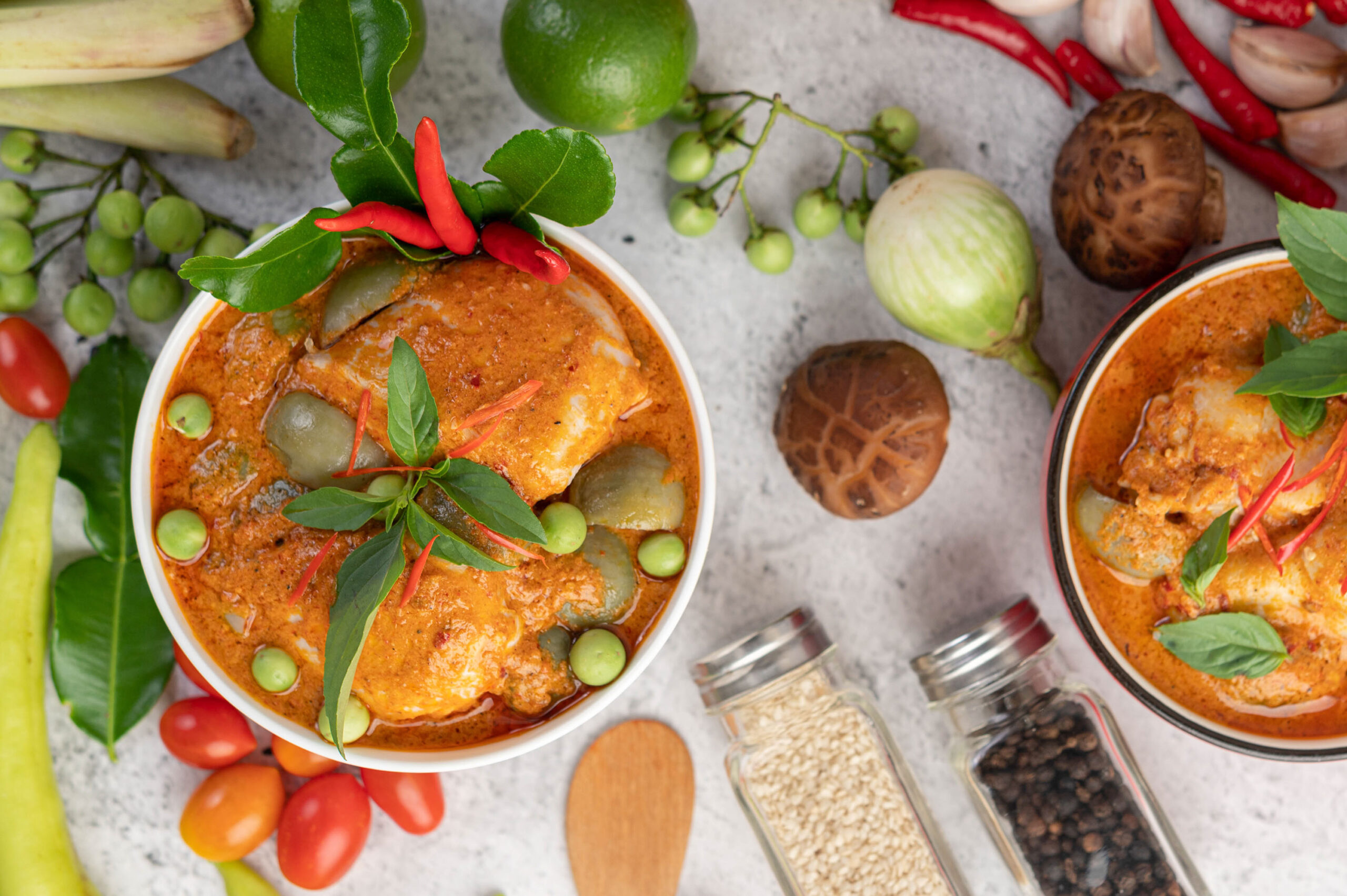 Chicken red curry in a black bowl, chilli, tomato, galangal, shiitake mushroom and eggplant